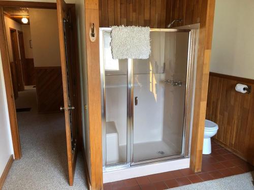 a glass shower in a bathroom with a toilet at River Run Inn in Winthrop