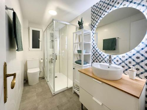 een badkamer met een wastafel, een douche en een spiegel bij Creatividad y personalidad en centro de Alicante in Alicante