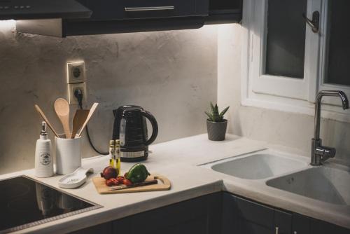 a kitchen counter with a sink and a cutting board with vegetables at Luxury katrinas apartment with outdoor jacuzzi in Corfu Town