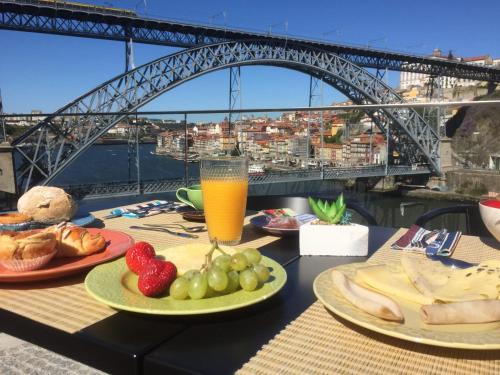 a table with plates of food and a bridge at Bridge It - Suites & Views in Vila Nova de Gaia