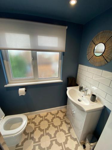 a bathroom with a sink and a toilet and a mirror at Lovely spacious loft close to train station in Worthing