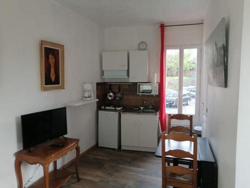 Zimmer mit einer Küche mit einem Tisch und einem Schreibtisch in der Unterkunft S2 Studio à Courtenay proche commerces in Courtenay