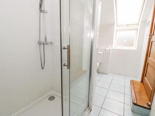 a shower with a glass door in a bathroom at Ddol Helyg Barn in Cwm-y-glo
