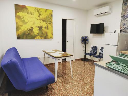 salon z niebieskim krzesłem i stołem w obiekcie La Casa de la Mimosa w Kordobie