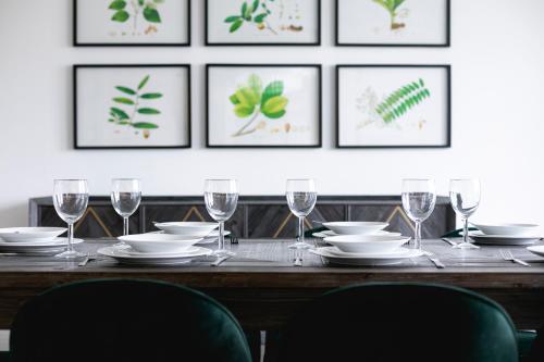 a dining room table with plates and wine glasses at ' Luxury & Spacious AirConditioned 4 Bed 4 Bath Apartment ' in London