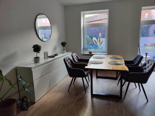 uma sala de jantar com uma mesa, cadeiras e um espelho em Neu sanierte Wohnung mit Balkon und Stellplatz em Erfurt