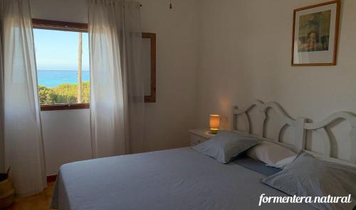 Schlafzimmer mit einem Bett und Meerblick in der Unterkunft Apto Mar de Es Caló, a metros de la playa - Formentera Natural in Es Caló