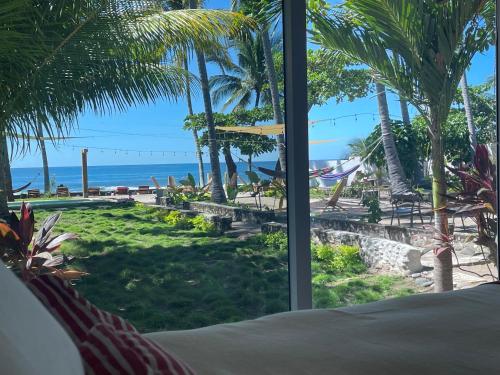 a bedroom with a view of the beach and the ocean at LOOKING2GOOD in El Zonte