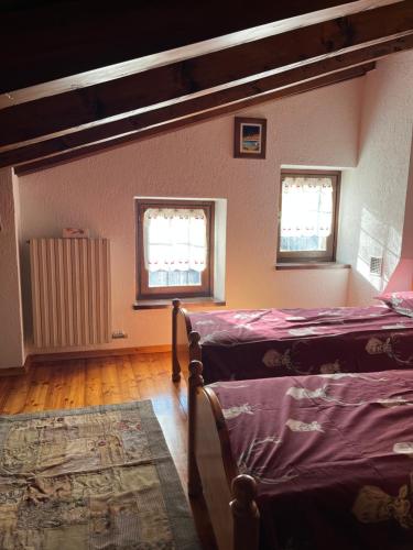a bedroom with two beds and two windows at Espoire - grande rochere in La Salle