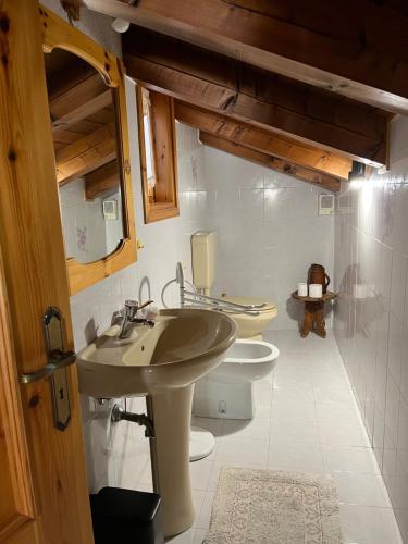 ein Badezimmer mit einem Waschbecken und zwei WCs. in der Unterkunft Espoire - grande rochere in La Salle