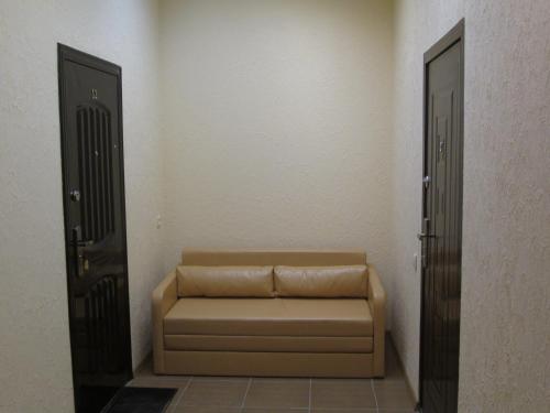 a couch sitting in a room with two doors at Rishelyevskiy in Odesa