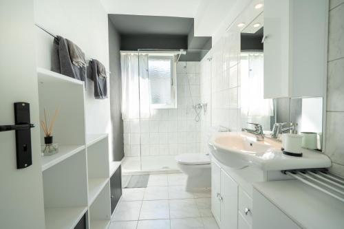 a white bathroom with a sink and a toilet at Charming Minusio Apartment, close to Locarno&Lake in Minusio