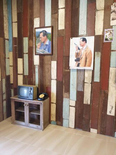 a room with a tv and pictures on a wall at No 9 HOUSE Hua Hin in Khao Tao