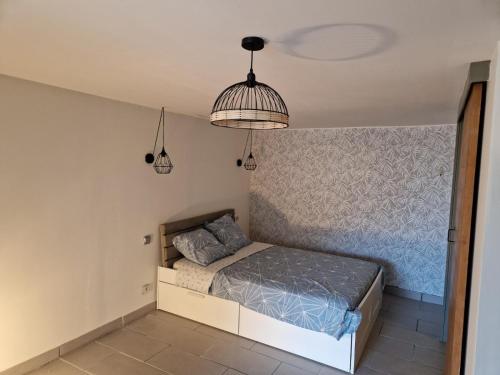 - une chambre avec un lit et deux lampes pendant dans l'établissement Charmant studio avec terrasse, à Saint-Cyprien