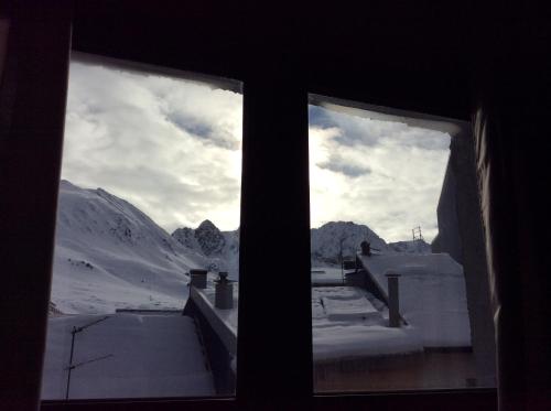 a view of a snowy mountain from a window at Hotel Merino in Pas de la Casa