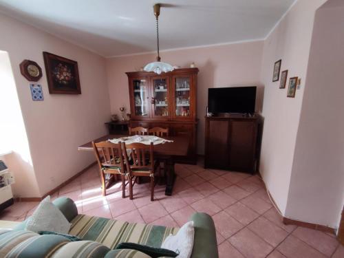 sala de estar con mesa y TV en Casa Vacanza Nonna Maria, en Calvi dellʼ Umbria