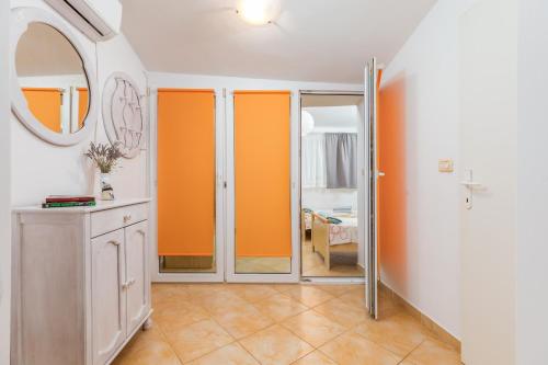 a room with orange sliding doors and a mirror at Apartment Dignano in Vodnjan