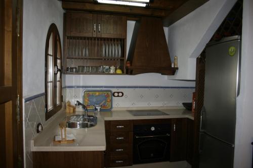 a small kitchen with a sink and a refrigerator at Casa Lentegí in Lentegí