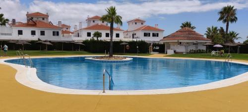 a large swimming pool in front of some houses at Casa con Tranquilidad in El Rompido
