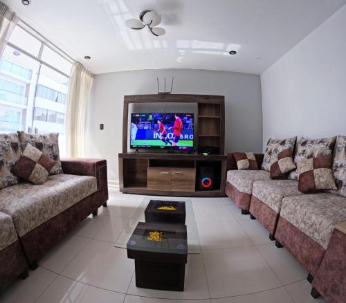 ein Wohnzimmer mit 2 Sofas und einem Flachbild-TV in der Unterkunft Departamento amplio y bonito en Arequipa in Arequipa