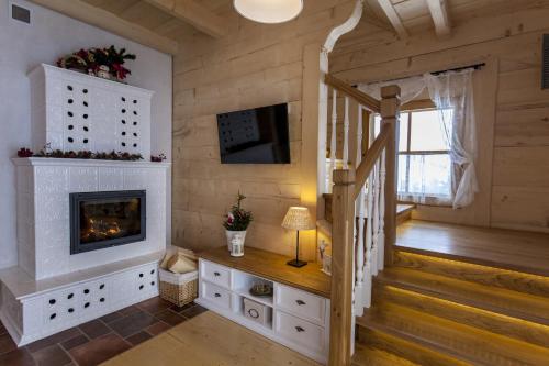 a living room with a fireplace and a staircase at Osada Maruszyna in Szaflary