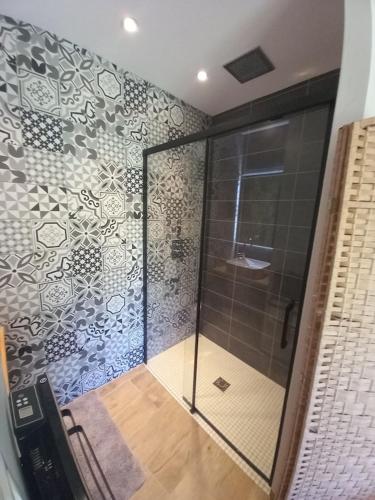 une douche avec une porte vitrée dans une salle de bain dans l'établissement Villa CASANOVA, à Santa-Reparata-di-Balagna