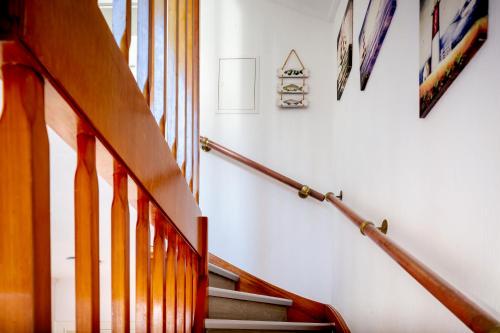 eine Treppe in einem Haus mit Holzgeländer in der Unterkunft Hummerklippen Ferienwohnungen in Helgoland