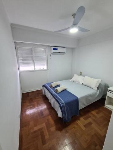 1 dormitorio con 1 cama y ventilador de techo en Departamento céntrico. en Bahía Blanca
