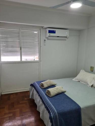 ein Schlafzimmer mit einem Bett mit zwei Kissen darauf in der Unterkunft Departamento céntrico. in Bahía Blanca