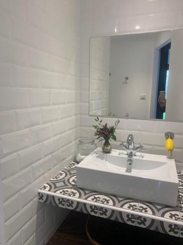 een witte badkamer met een wastafel en een spiegel bij Villa 37 in Courrejean