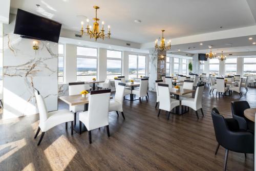 a restaurant with white chairs and tables and windows at Halifax Tower Hotel & Conference Centre, an Ascend Collection Hotel in Halifax