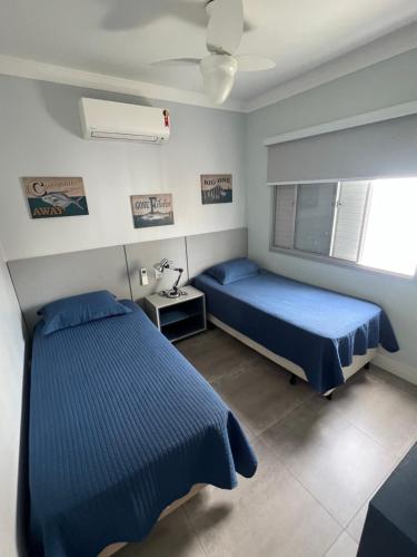 une chambre avec deux lits et une fenêtre dans l'établissement Apartamento Impecável Completo próximo à praia com Barco Opcional, à Guarujá