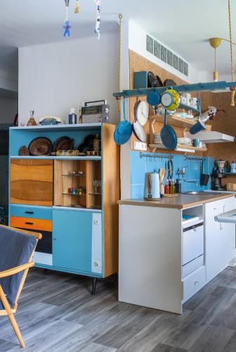 a kitchen with blue and white cabinets and a table at Retro Art room in Lomnice nad Popelkou