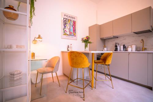 - une cuisine avec des chaises jaunes et un comptoir dans une pièce dans l'établissement Boutique Hotel Kerlin, à Berlin