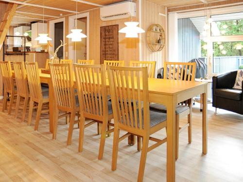 a dining room with a wooden table and chairs at Luxury Retreat with Pool - By Traum Ferienwohnungen in Nørre Nebel
