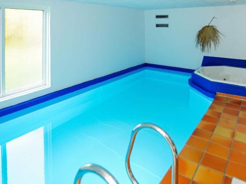 a swimming pool with a tub in a room at Luxury Retreat with Pool - By Traum Ferienwohnungen in Nørre Nebel