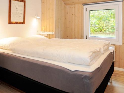 Cette chambre comprend un grand lit et une fenêtre. dans l'établissement Holiday home Nørre Nebel XXX, à Nørre Nebel