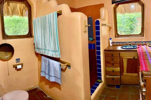 baño con ducha y lavabo en un tren en Lake Front house, cozy and comfortable., en Santa Cruz La Laguna