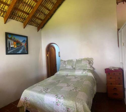 1 dormitorio con 1 cama y una foto en la pared en Lake Front house, cozy and comfortable., en Santa Cruz La Laguna