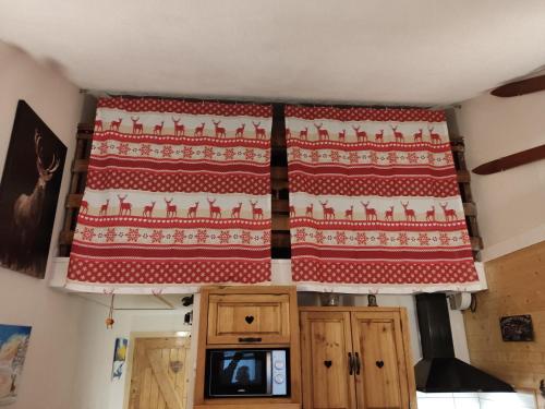 a red and white rug hanging on a kitchen ceiling at LES FONTANILLES odeillo chalet 60 WIFI & PARKING gratuit exposé plein sud & plein pied , draps & serviettes de toilettes non inclus, sabanas y toallas no incluidos in Font-Romeu-Odeillo-Via