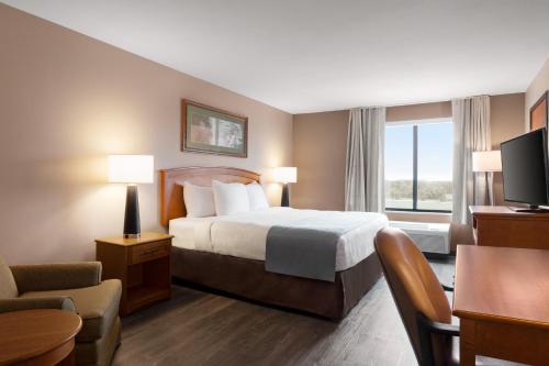 um quarto de hotel com uma cama e uma janela em Wingate by Wyndham Bentonville em Bentonville