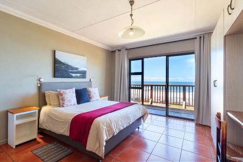 a bedroom with a bed with a view of the ocean at Mitford Memories in Morganʼs Bay
