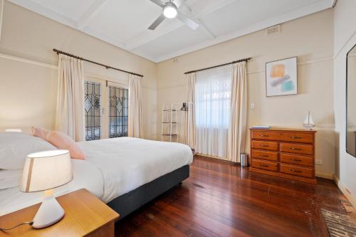 a bedroom with a bed and a dresser and a lamp at Swainson on Coombe in Woodville