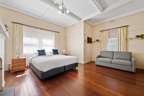 a bedroom with a bed and a couch and a chair at Swainson on Coombe in Woodville