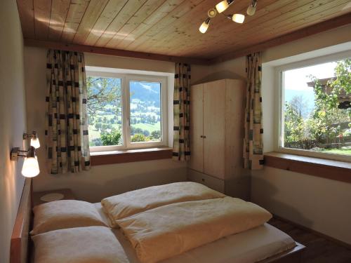 2 Betten in einem Zimmer mit 2 Fenstern in der Unterkunft Appartement Laiminger in Brixen im Thale