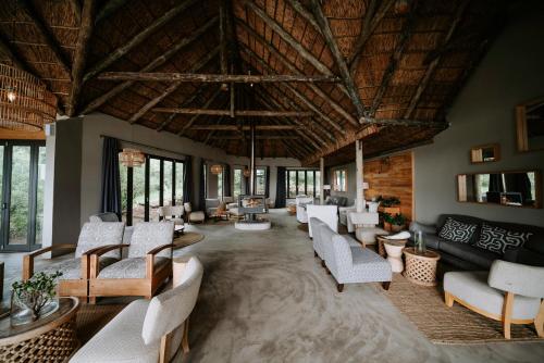 a large living room with white furniture and a wooden ceiling at Bukela Game Lodge - Amakhala Game Reserve in Amakhala Game Reserve