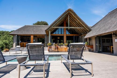 a group of chairs sitting on a patio in front of a building at Bukela Game Lodge - Amakhala Game Reserve in Amakhala Game Reserve
