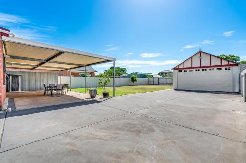 a patio with a white garage and a red building at Swainson on Coombe in Woodville