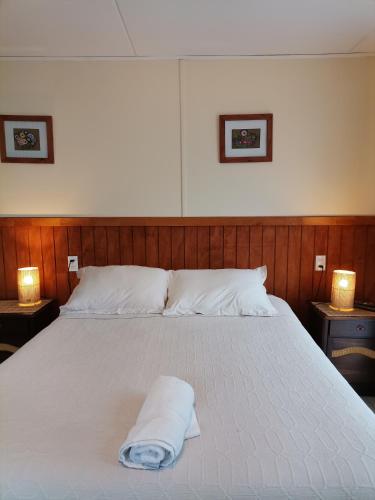 a white bed with a towel on top of it at Departamento Rossbach in Puerto Puyuhuapi