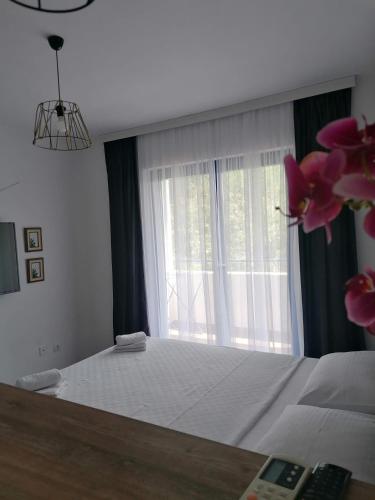 um quarto com uma cama grande e uma janela em Apartmani Pasara em Baošići